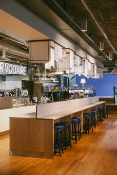 Interiör av restaurang med en lång bardisk och hög sittplats.
