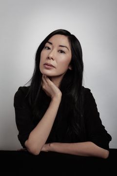 Porträtt av Katie Kitamura i mörka kläder mot en vit bakgrund.
