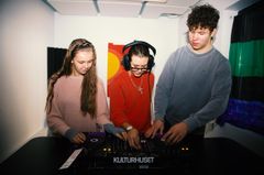 En grupp unga personer mixar musik tillsammans i ett rum.