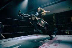 Wrestlare uppträder på en belyst scen inför en publik.