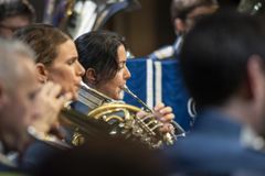 Musiker spelar blåsinstrument i en orkester.