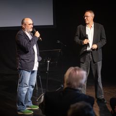 Årets hederspristagare Dmitri Plax vid prisutdelningen av Bennypriset på Kulturhuset Stadsteatern Vällingby. Här i samtal med Johan Wirfält.