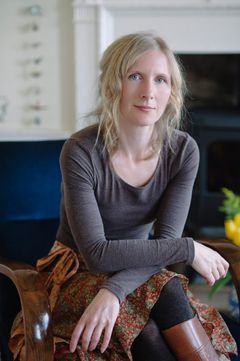 Porträtt av Samantha Harvey med ljust hår, sittande i en fåtölj med armarna vilande över benen.