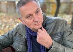Porträtt av Georgi Gospodinov med kort grått hår, skinnjacka och blå halsduk, fotograferad utomhus.