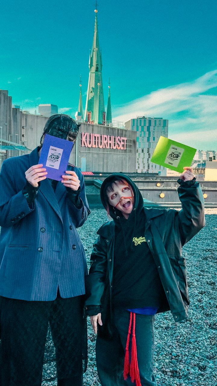 Två maskerade personer på Kulturhustaket