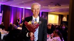 En person med blommor mottar guldklubba vid en förbundsmötesmiddag.