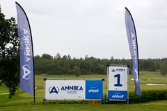 Alt text: Två flaggor och en skylt för ANNIKA Invitational Europe på Upsala Golfklubb. I bakgrunden syns golfbanan.