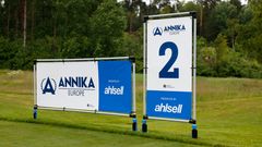 Två skyltar med texten "ANNIKA Invitational Europe presented by Ahlsell" på golfbana.