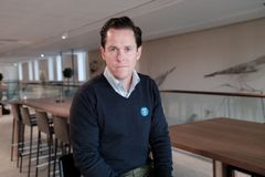 En person sitter vid ett bord i en modern kontorsmiljö.