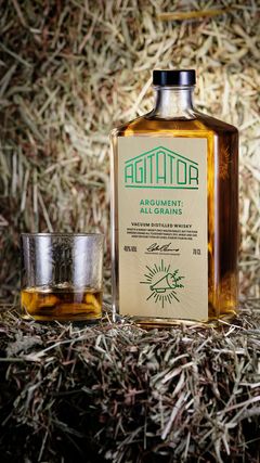 Flaska med whisky och ett glas på hö.