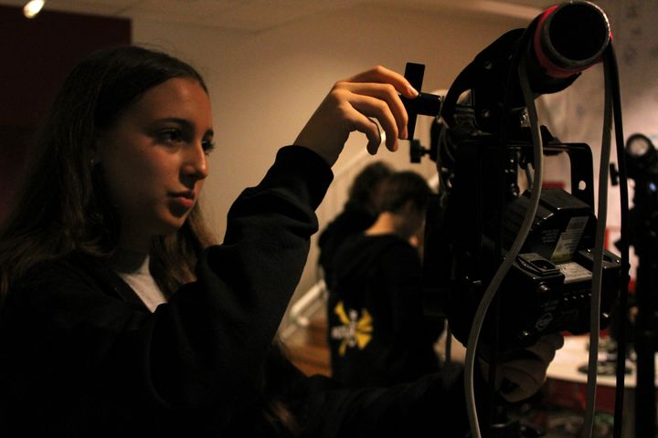 En ung person riggar belysningsutrustning.