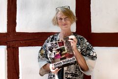 Kvinna håller upp boken "Sven Fristedt – mästare i mönster".