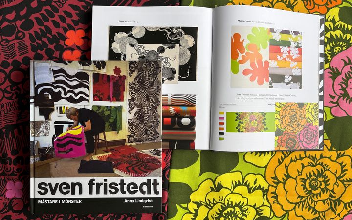 Bokomslag och uppslag ur boken "Sven Fristedt – mästare i mönster", mot en bakgrund av färgglada tyger med Sven Fristedts mönster.