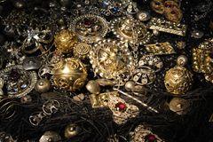 Alt text: Närbild av detaljerade, antika dräktsmycken i silver och guld, dekorerade med röda stenar.