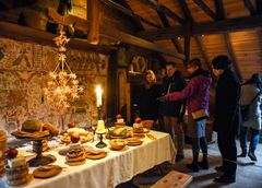 Fyra personer betraktar ett juldukat bord i Blekingegården, ett av de historiska husen på Kulturen i Lund.
