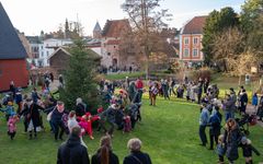 Personer dansar runt en julgran utomhus.