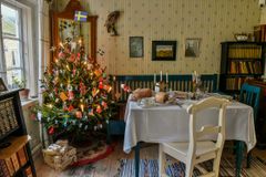Juldekorerat rum på 1930-talet med julgran med elektrisk belysning och dukat matbord,  i Arbetarbostaden på Kulturen i Lund.