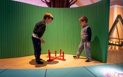 Barn leker med en ringkastningslek i en lekutställning.