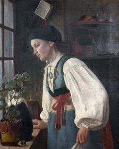 En ung kvinna i skånsk folklig dräkt står vid ett fönster och tittar ut.