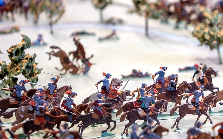 Detalj från diorama som visar tennfigurer, med soldater på hästar och i strid.