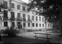 Svartvit bild av Vita husets entré dekorerad för en konstutställning 1929, med människor som står vid trappan.