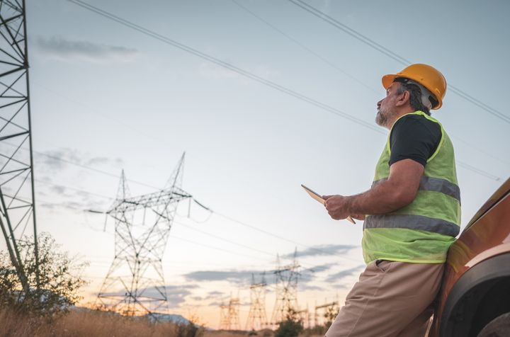 En man utför tillsyn av en kraftledning