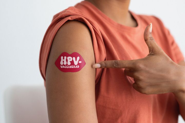 Kvinnas överarm med plåster med texten HPV-vaccinerad