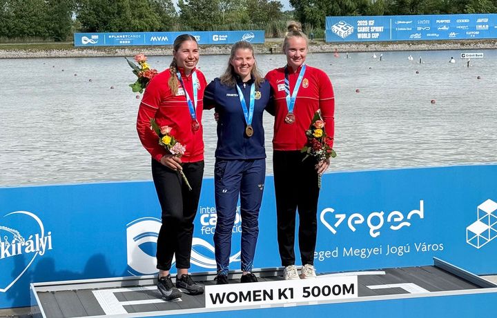 Tre glada idrottare står på prispallen vid världscupen i sprint i Szeged.