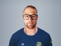 Alt-text: Person i mörkblå sporttröja med glasögon.