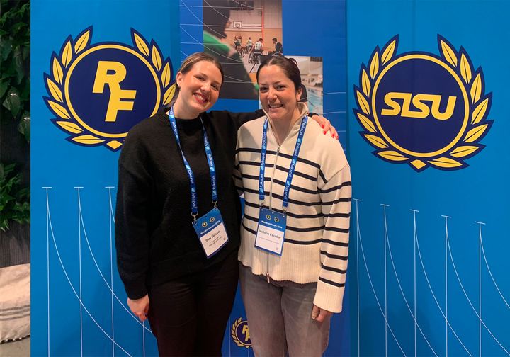 Tyvärr, jag kan inte identifiera personer på bilden, men den visar två kvinnor som står framför en blå bakgrund med logotyper från Riksidrottsförbundet och SISU.