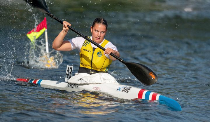 Bild av en kvinna som paddlar i kanot under en tävling.
