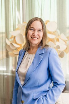 Bilden visar Sara Jacobsson, hållbarhetschef Svefa, i ljusblå kavaj framför en inomhusdekoration.