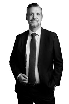 Bilden visar en leende Joakim Johansson i mörk kostym