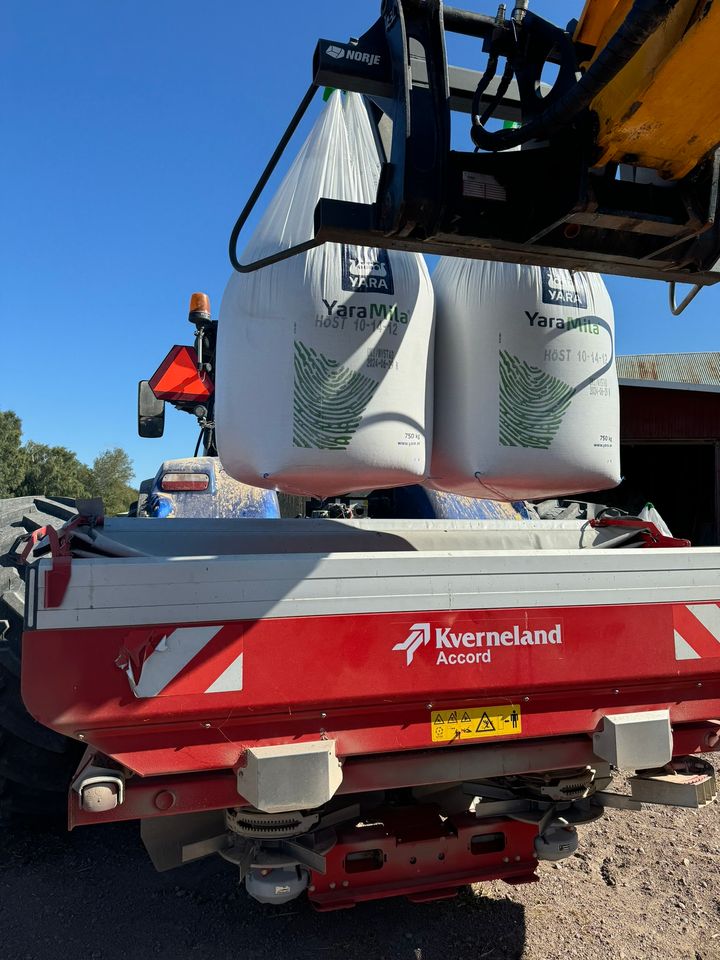 En maskin lastar vita säckar märkt "Yara" på en Kverneland jordbruksmaskin.