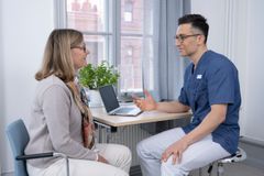 Alt text: Läkare i samtal med patient på en mottagning.