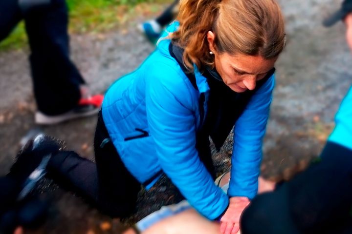 Kvinna utför hjärt-lungräddning utomhus.