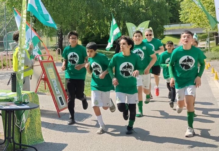 En grupp med ugndomar i gröna t-shirts springer i en klunga.