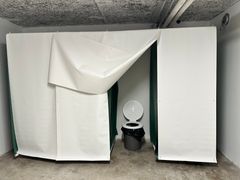 Bås med provisoriska toaletter i ett skyddsrum.