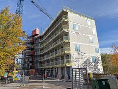 Ett höghus under uppförande med byggställningar och byggkran.