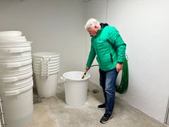 Tony Baptiste fyller hink med vatten