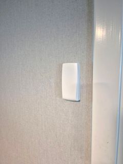 Vit fyrkantig sensor på vägg