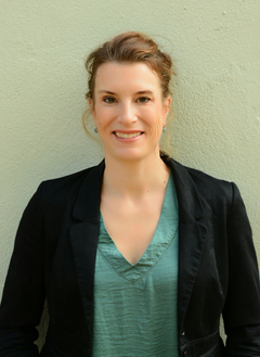 Foto på Josefin Lilja, som har mörkt uppsatt hår och är klädd i mörk kavaj över grön tröja