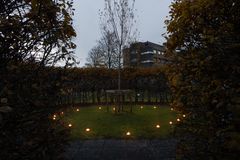 En korallpil omgiven av tända ljus och häckar nära huvudentrén på NÄL i Trollhättan.