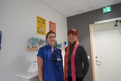 En sjuksköterska och en kurator står vid sprututbytesmottagningen och ler mot kameran.