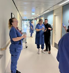 En grupp vårdpersonal står i en sjukhuskorridor.