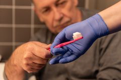 Bild som visar äldre person som får hjälp med att borsta tänder