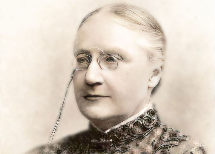 En svartvit porträttbild av en kvinna med glasögon och håruppsättning.