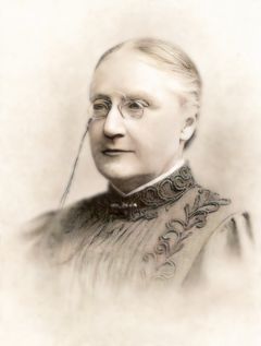 Porträtt av Charlotte von Schéele i äldre stilkläder och monokel.