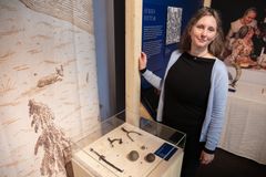 Greta Åberg, museipedagog på Vänersborgs museum, framför en monter med föremål som vittnar om Brättes utsatta läge: kanonkulor, muskötkula, stigbyglar och en dolk.