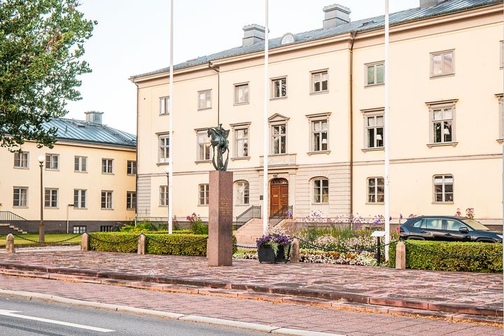 Bild av en byggnad med ljusgul fasad och grått tak.